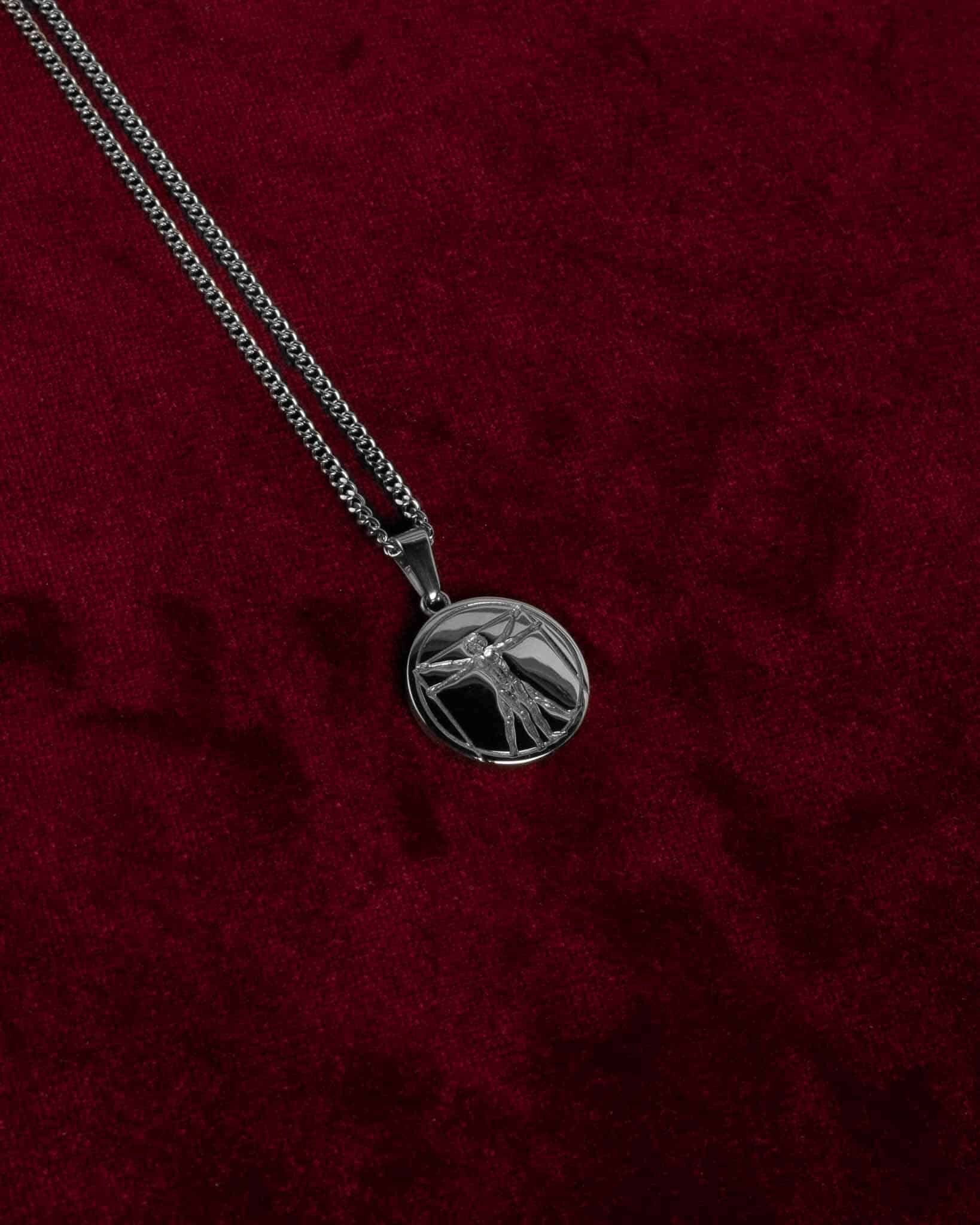 Ett halsband med Da vinci ingraverat på ett cirkelformat silverhängsmycke