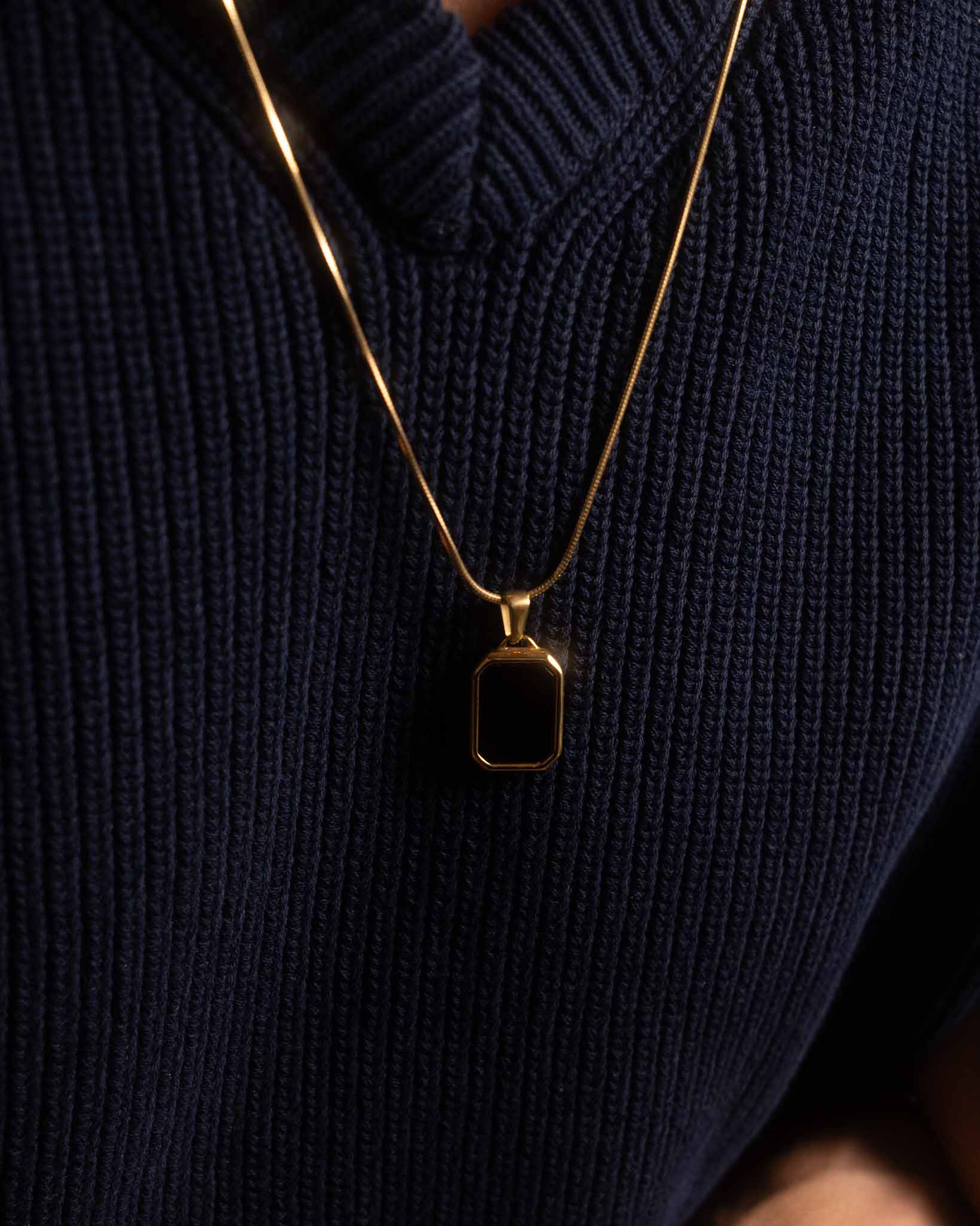 Tunt halsband i guld med svart onyx hänge i rektangulär form